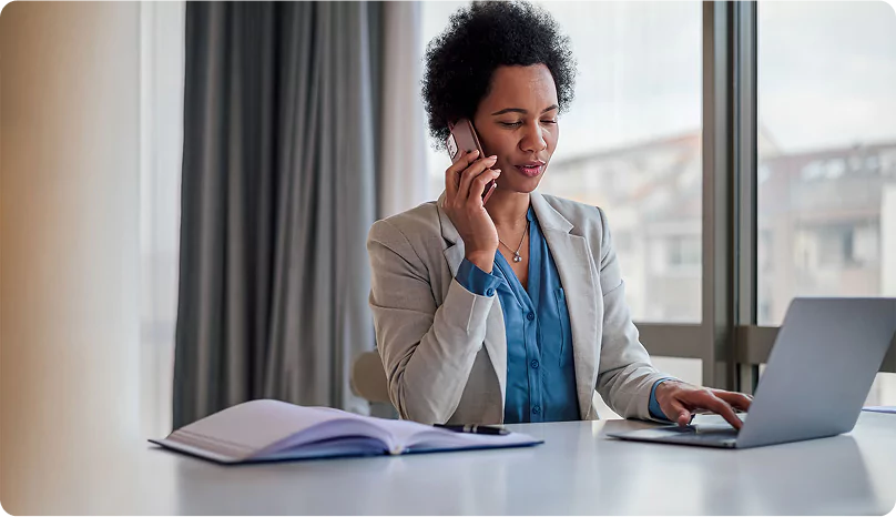 Workforce Accommodation Coordinator Arranging FIFO Worker Housing Professional coordinator on the phone and using a laptop to schedule FIFO worker housing.