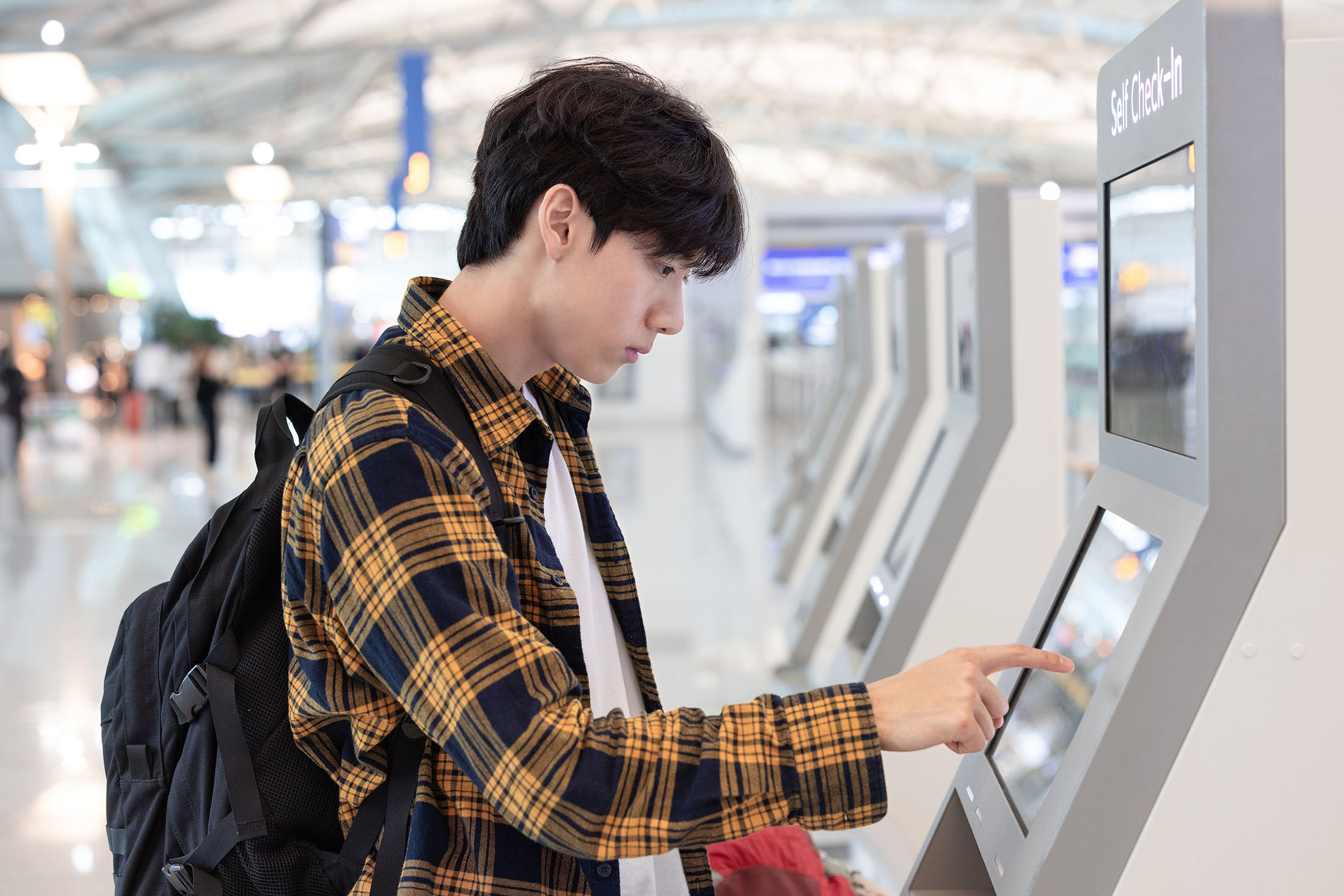 man-checks-in-kiosk-airport