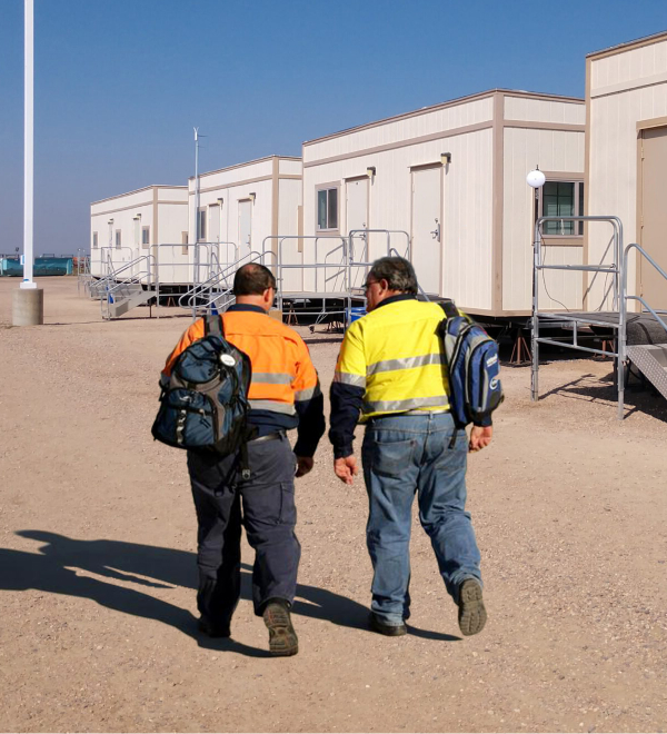 two-men-walk-alongside-portable-modulars