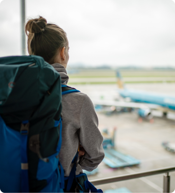 woman-backpack-looks-onto-plane-airport