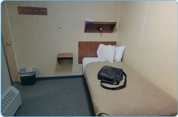 Vacant bedroom with a bag placed on bed in a remote FIFO camp.