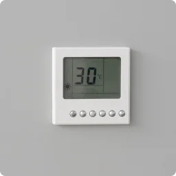 Thermostat attached to wall displays warm temperature.