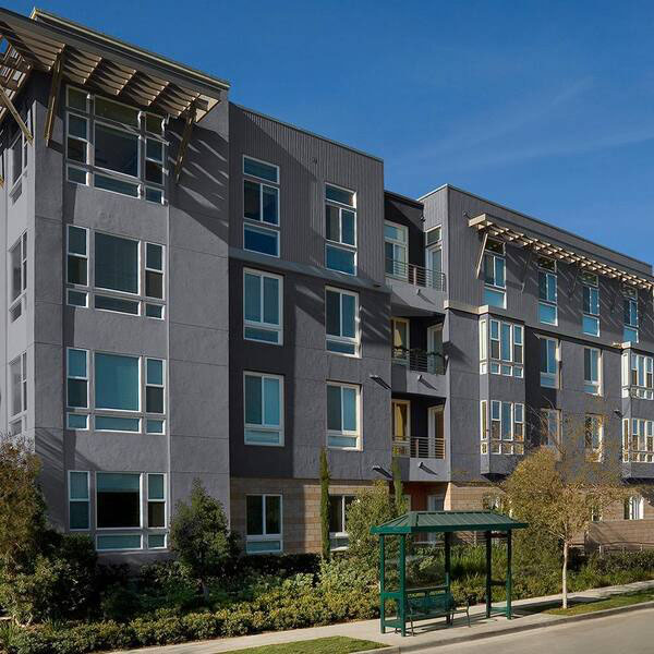 Apartment building designed with a modern construction style with multiple windows.