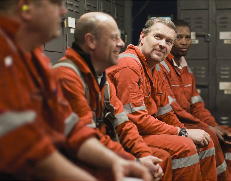 FIFO workers sit and chat in a locker room.